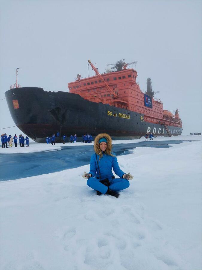 Алена Антонова сидит в позе для медитации рядом с атомным ледоколом «50 лет Победы»